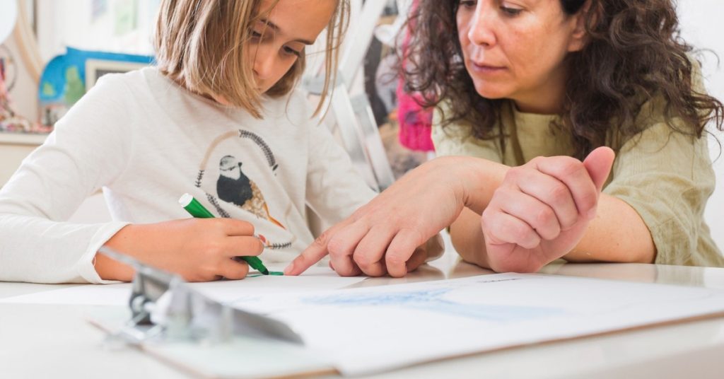 Professeur particulier aidant une fille à travailler les mathématiques à la maison
