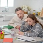 Image illustrant le soutien scolaire à domicile avant le brevet 2026 : un parent accompagne une adolescente pendant ses révisions dans un cadre calme et rassurant.