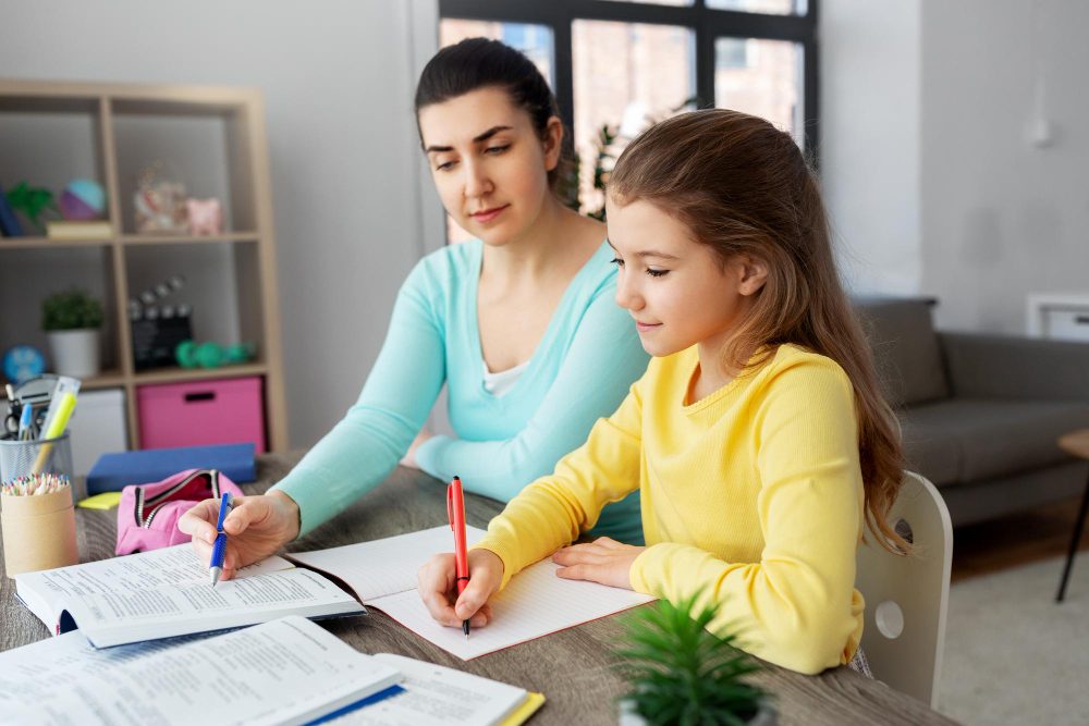 Professeure particulière aidant une élève pendant un cours de maths à domicile à Marseille